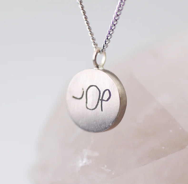 de tekst in het sieraad